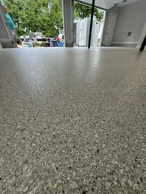 Gray speckled countertop or floor in a modern open room with a view outside