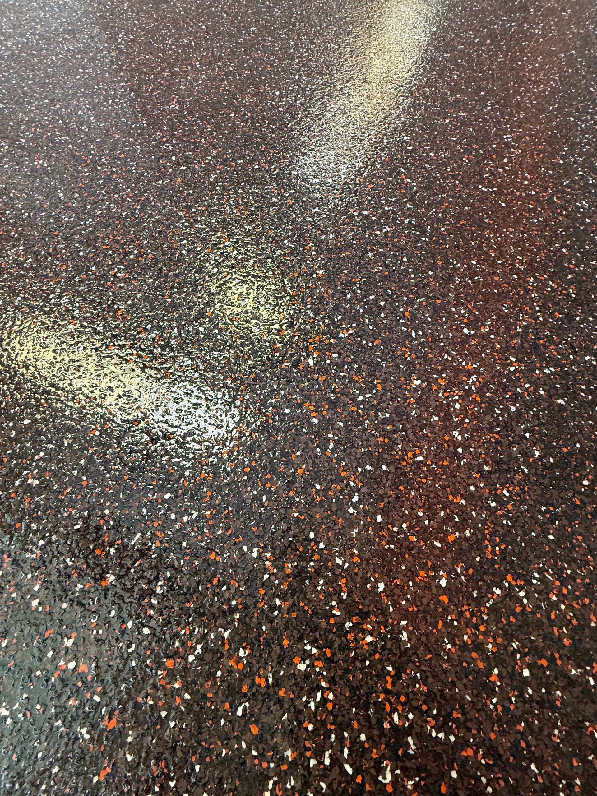 Abstract glittering confetti with silver, gold, and orange specks on a dark background