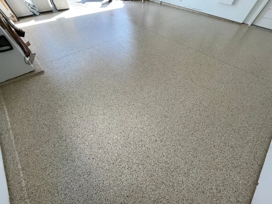 Empty speckled beige floor in a bright indoor room with sunlight near the doorway