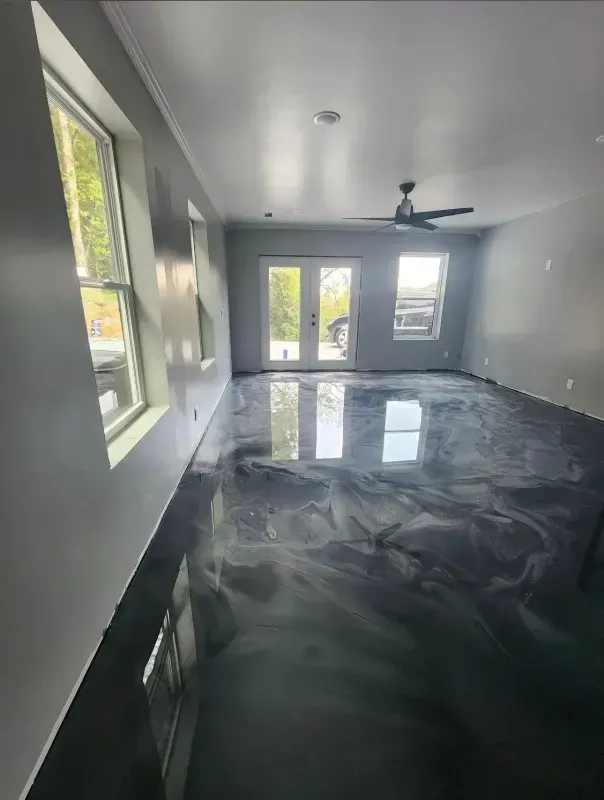 Bright modern room with gray walls, large windows, ceiling fan, and glossy reflective floor finish