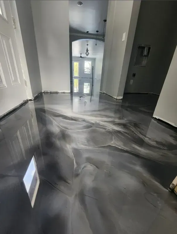 Empty hallway with glossy black marbled floor and a glass front door at the far end.