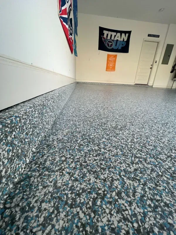 Empty hallway with speckled carpet, white walls, a Titan sign, and a partially visible Union Jack flag.