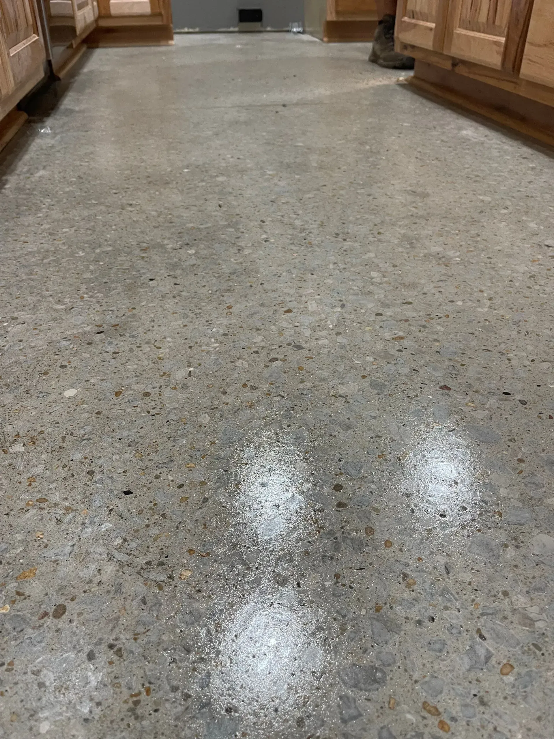 Concrete floor with patches of white residue, likely cleaning products.