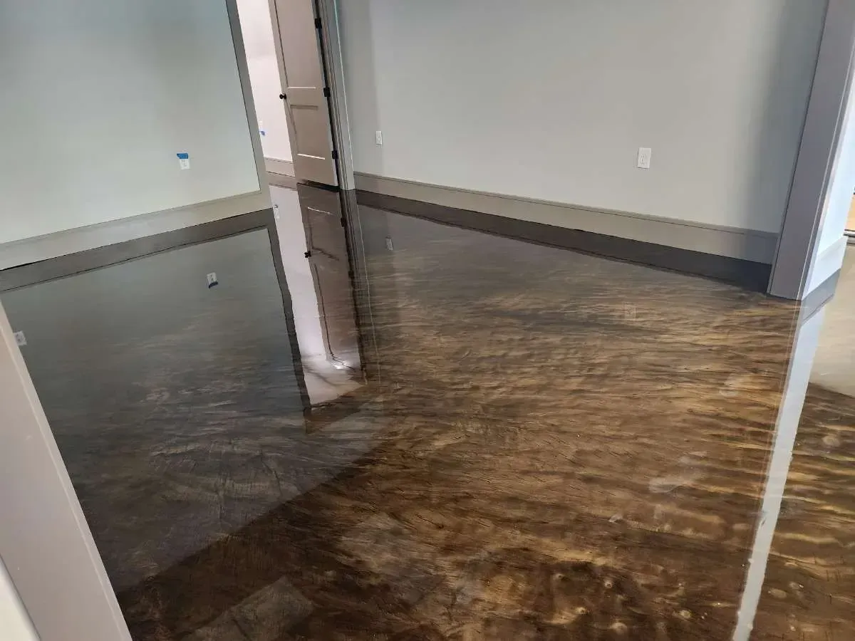 Interior view of a room with shiny, brown-colored concrete flooring; walls are painted light gray.