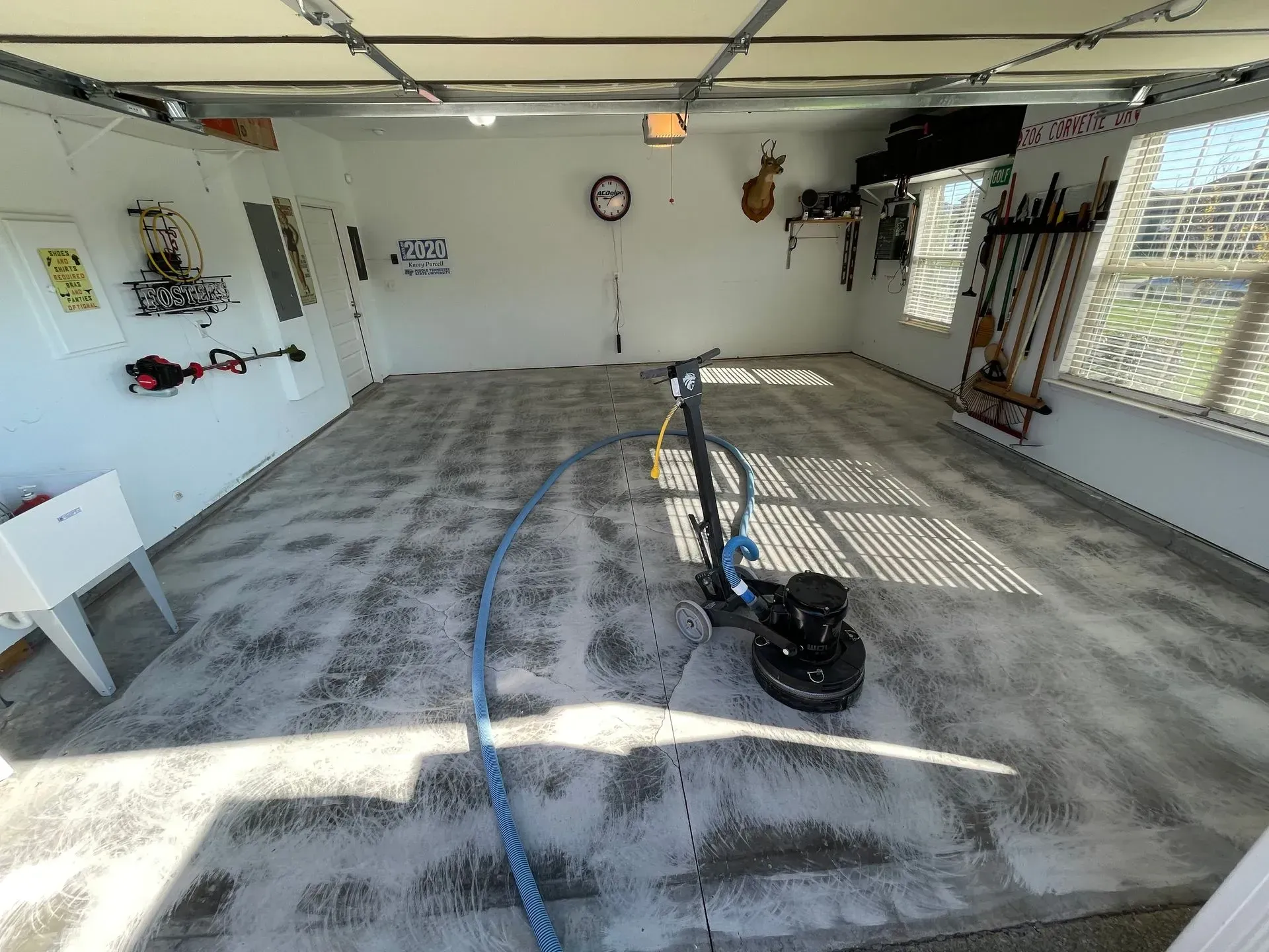 Garage with concrete floor being cleaned by a machine.