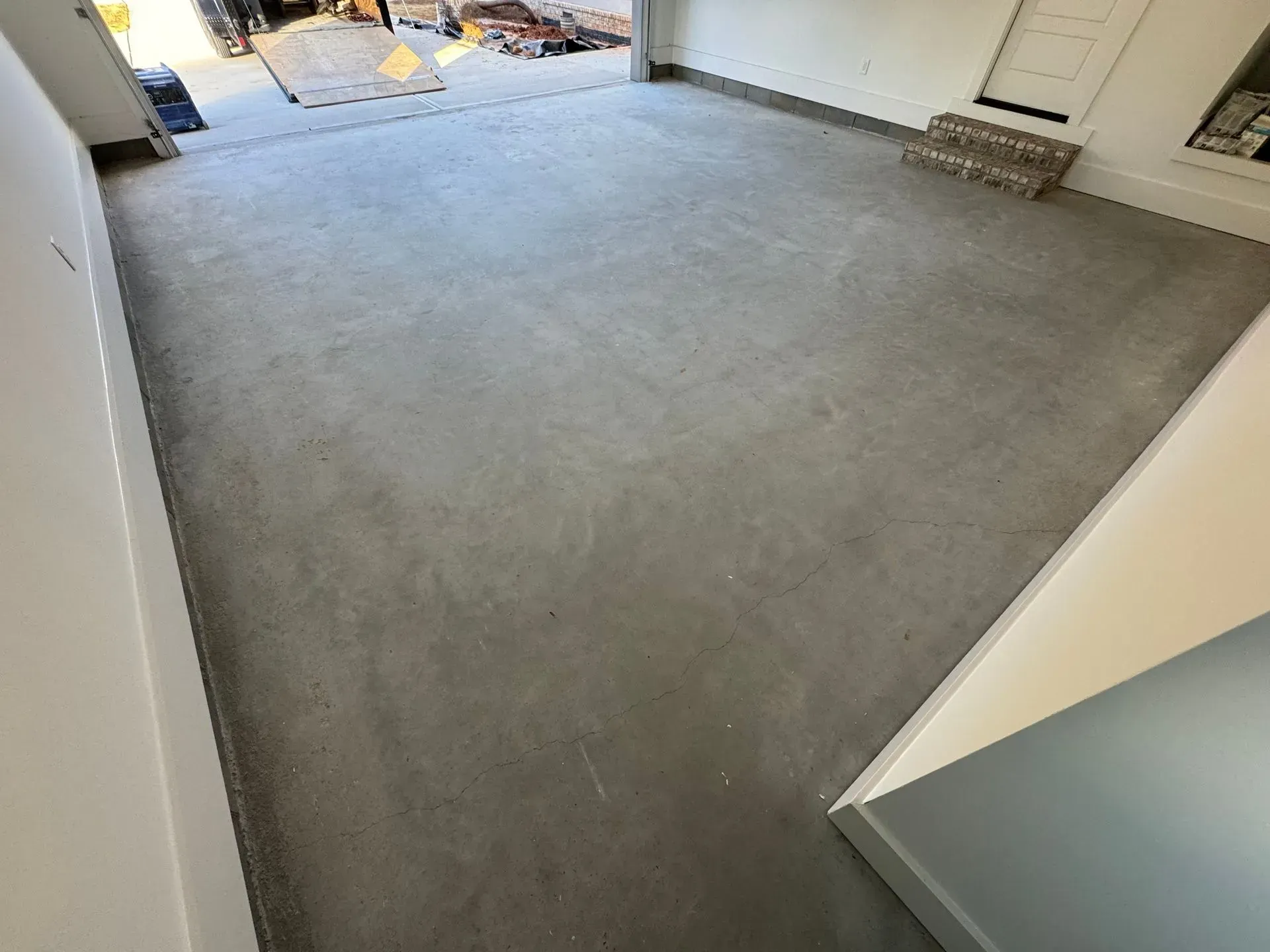 Empty garage with gray concrete floor and white walls.