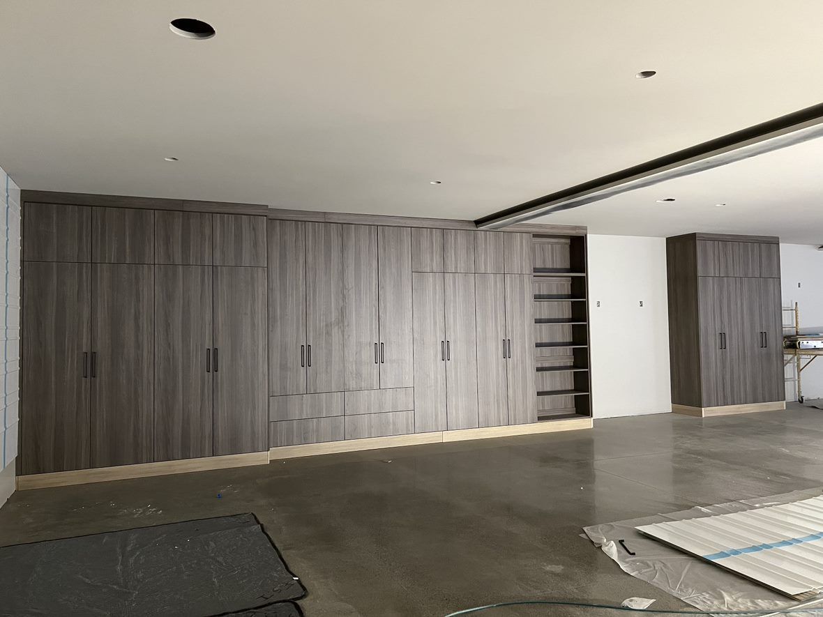 Large gray storage cabinets in a room with a concrete floor and unfinished walls.