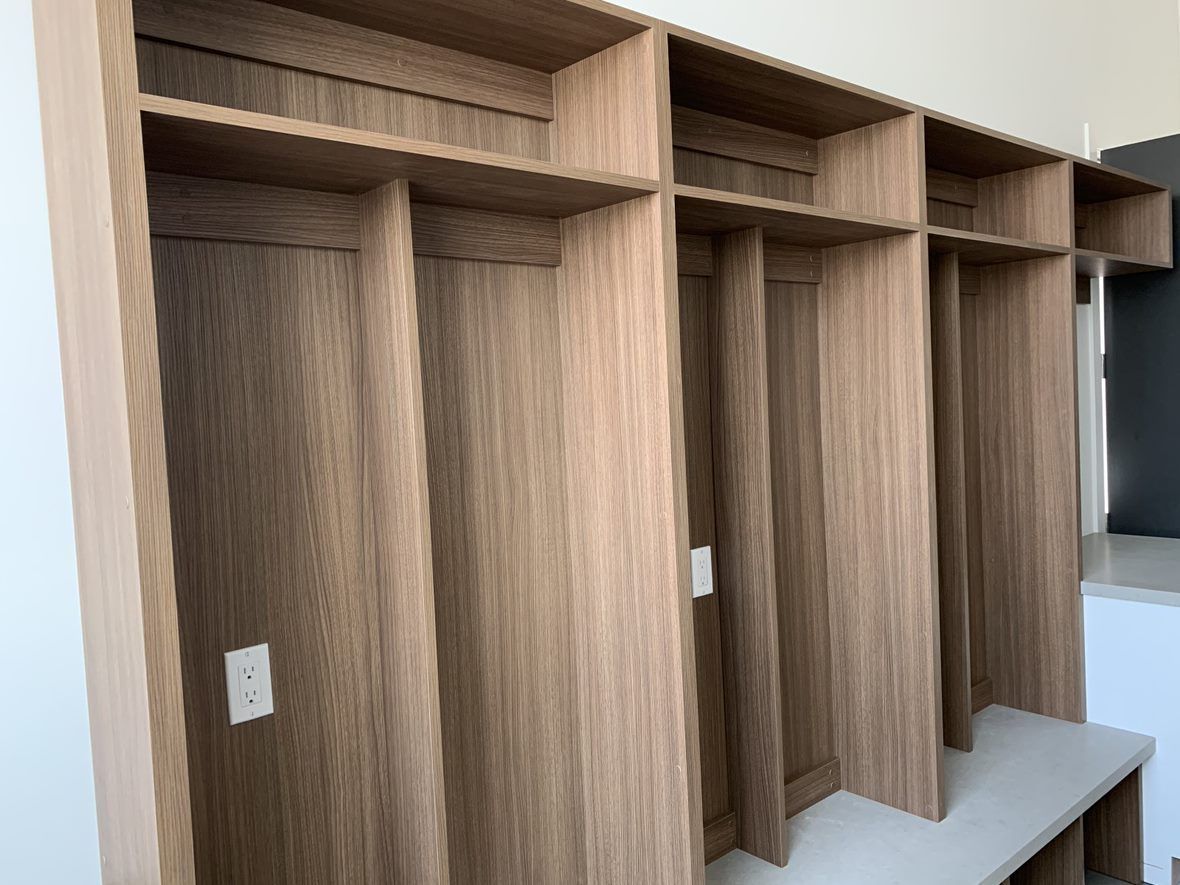 Wooden built-in storage unit with shelves and vertical compartments, in a home.