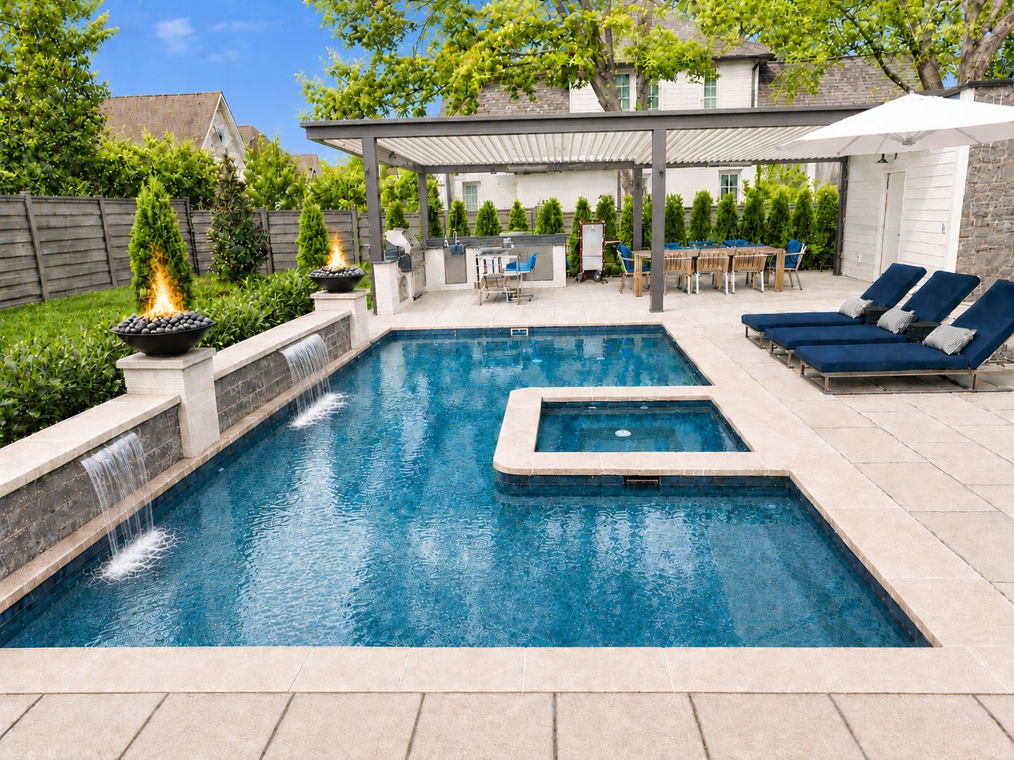 Backyard pool with blue water, spa, lounge chairs, pergola dining area, and fire feature