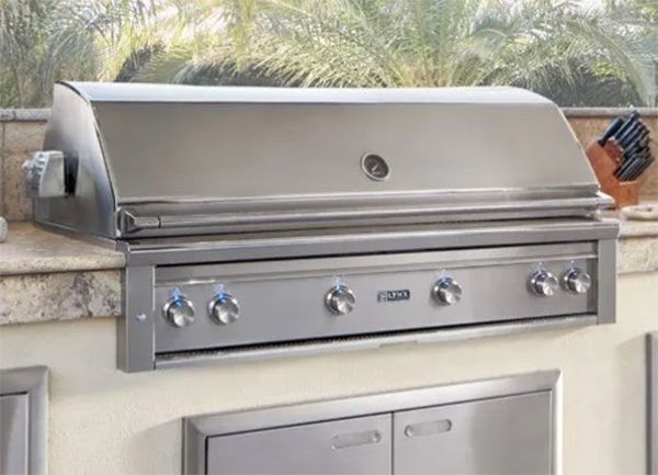 Stainless steel outdoor grill built into a countertop with control knobs.