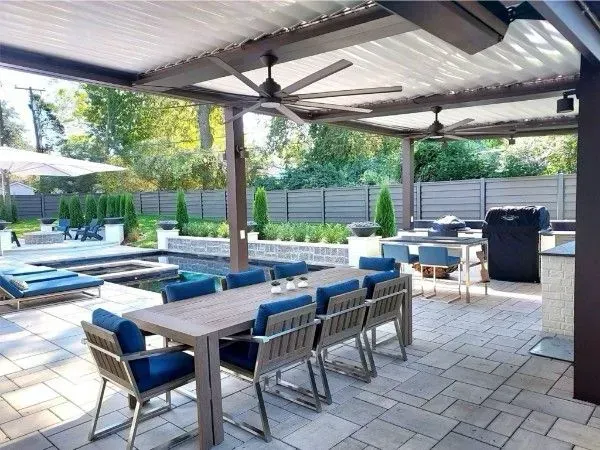 Patio with dining table, blue chairs, pool, pergola, and ceiling fans.