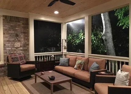 Outdoor living room with seating, a coffee table, and open view of the night.