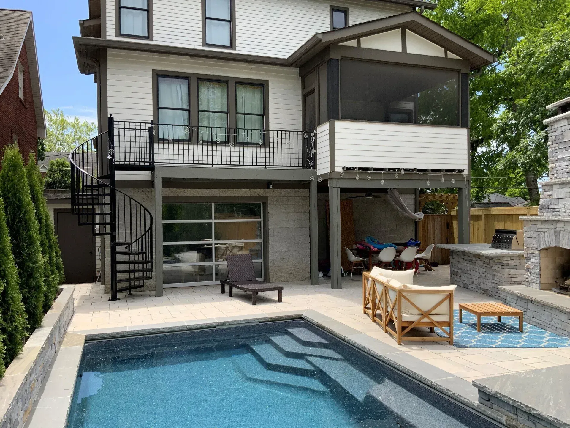 Backyard with pool, deck, screened porch, and spiral staircase. Includes lounge furniture and outdoor fireplace.
