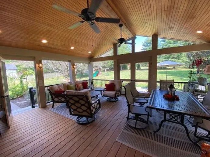 Patio with a pergola, dining table, and outdoor kitchen, overlooking a yard.