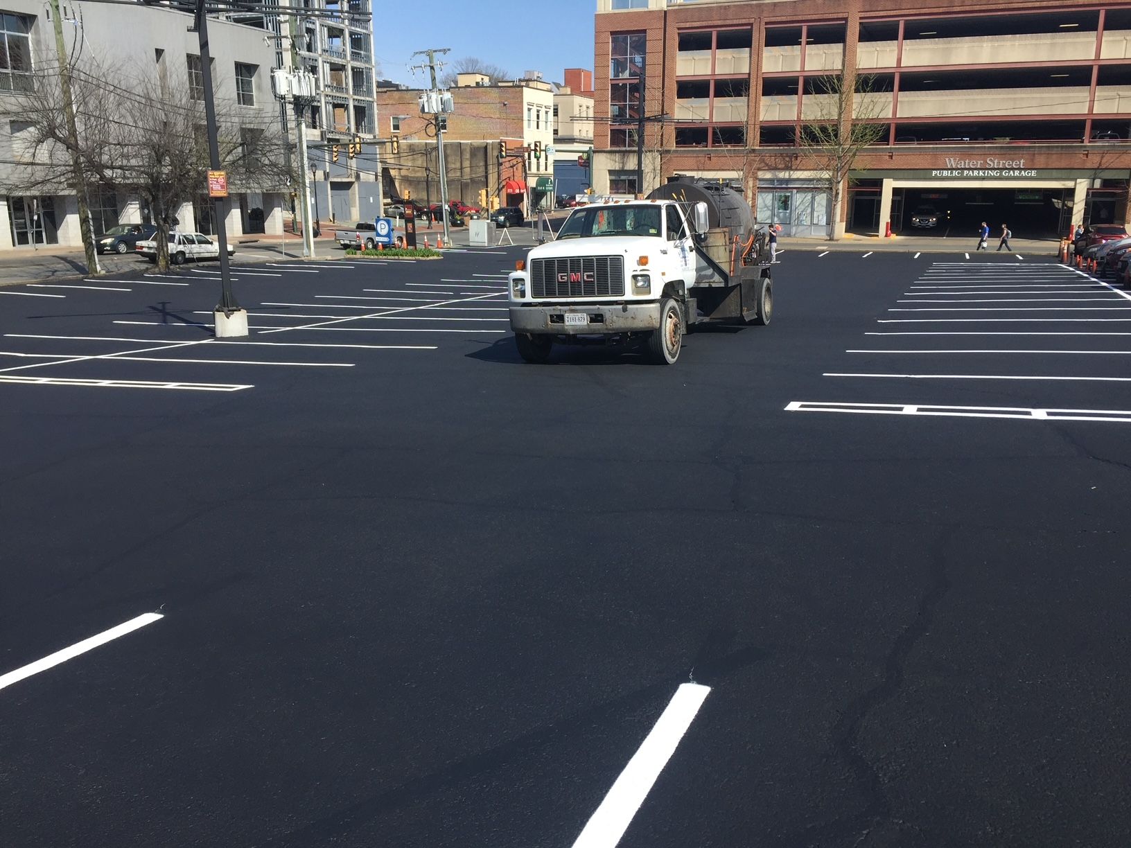 GMC truck is driving through a parking lot