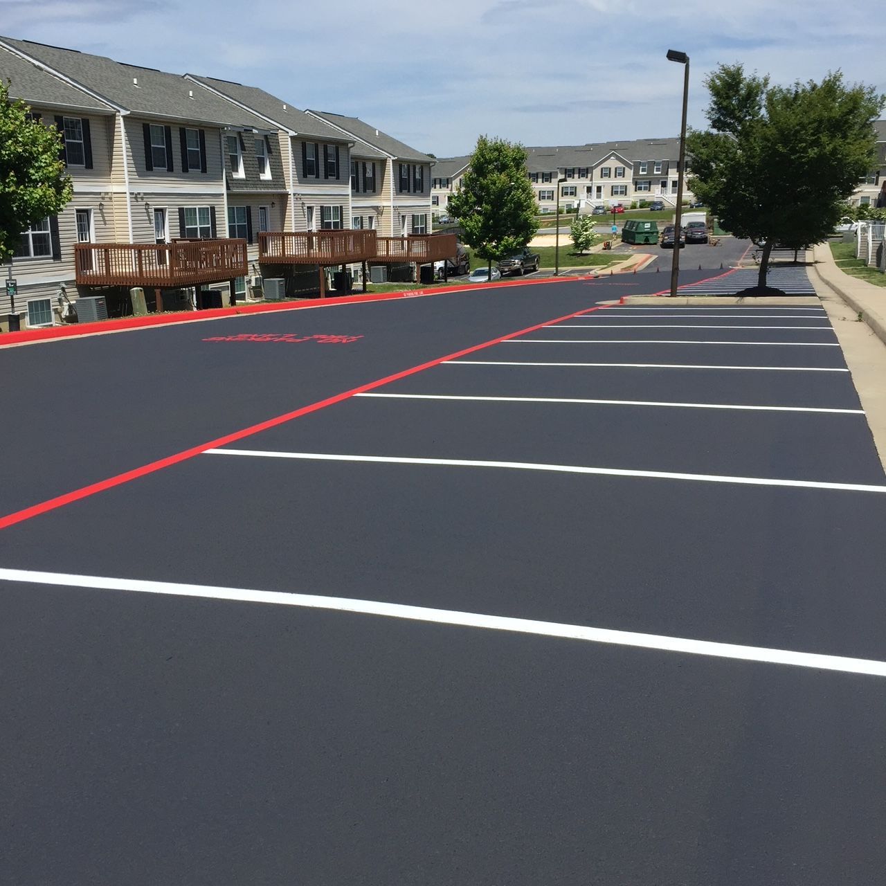 a parking lot in front of a row of apartment buildings