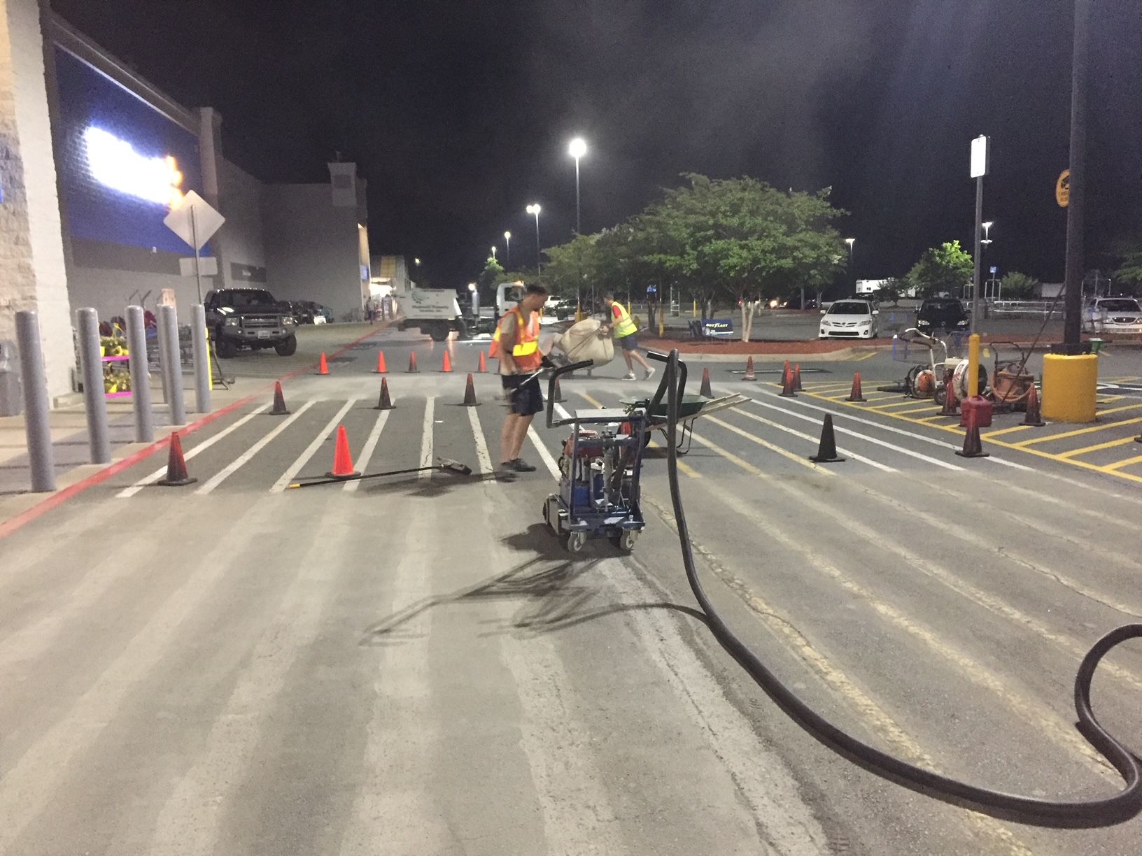 a group of people are working on a parking lot at night