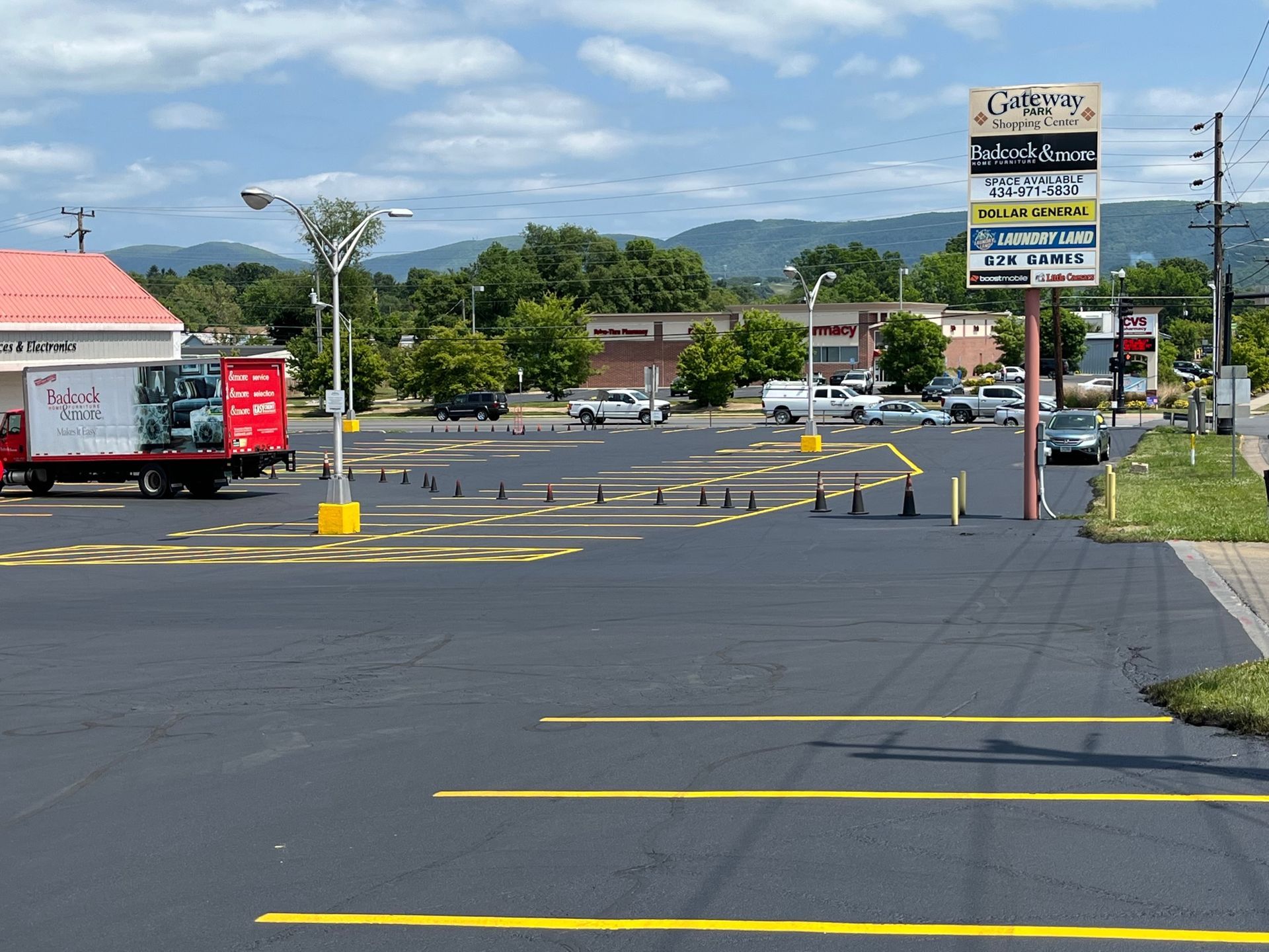 a red truck is parked in a parking lot in front of a store