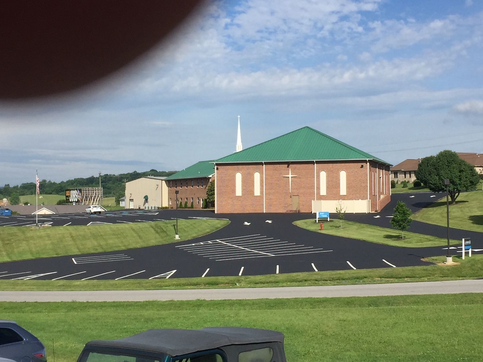 a jeep is parked in front of a church with a green roof