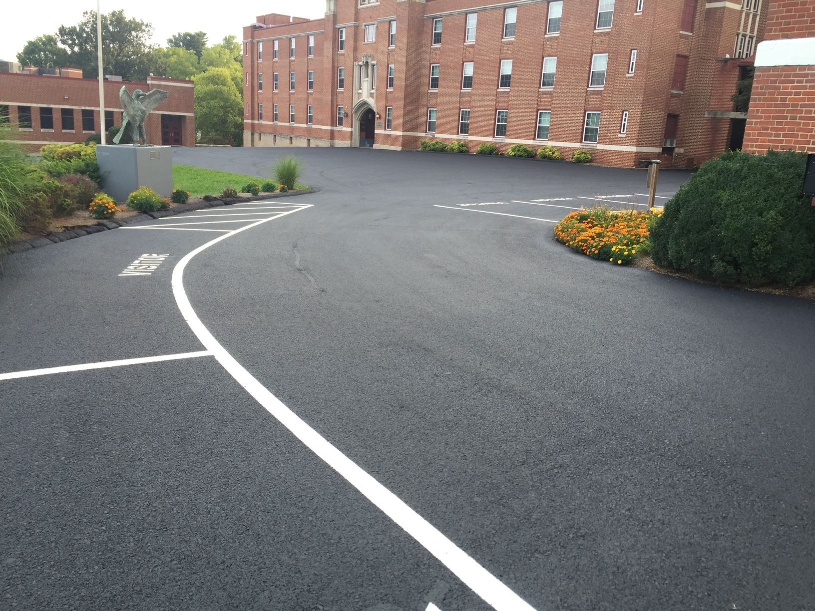 a large brick building is behind a curvy parking lot
