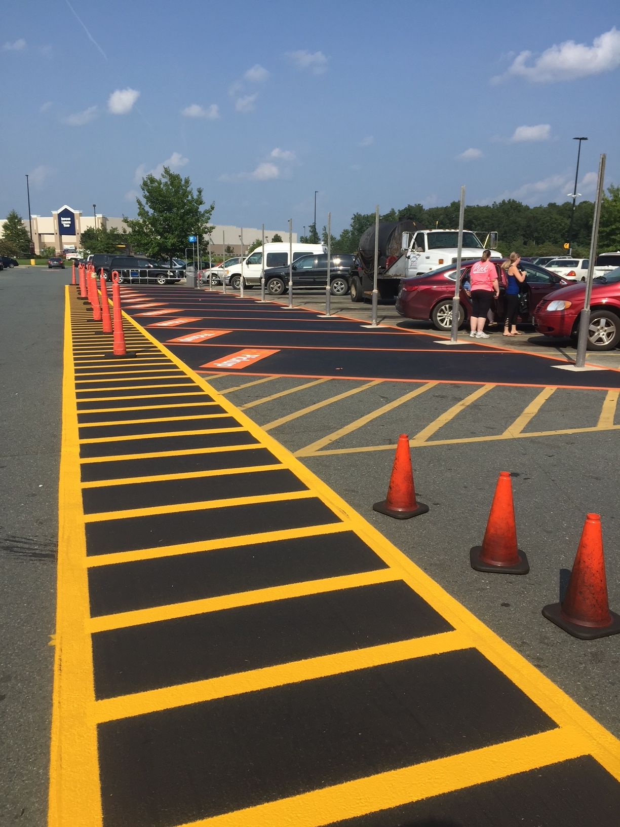 a parking lot with yellow lines and orange cones