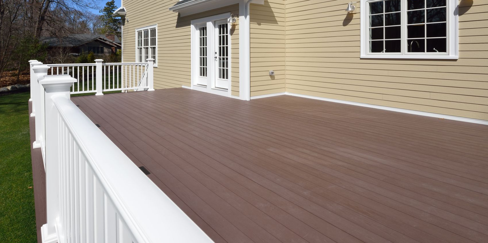 White house corner with gutter system against a blue sky.