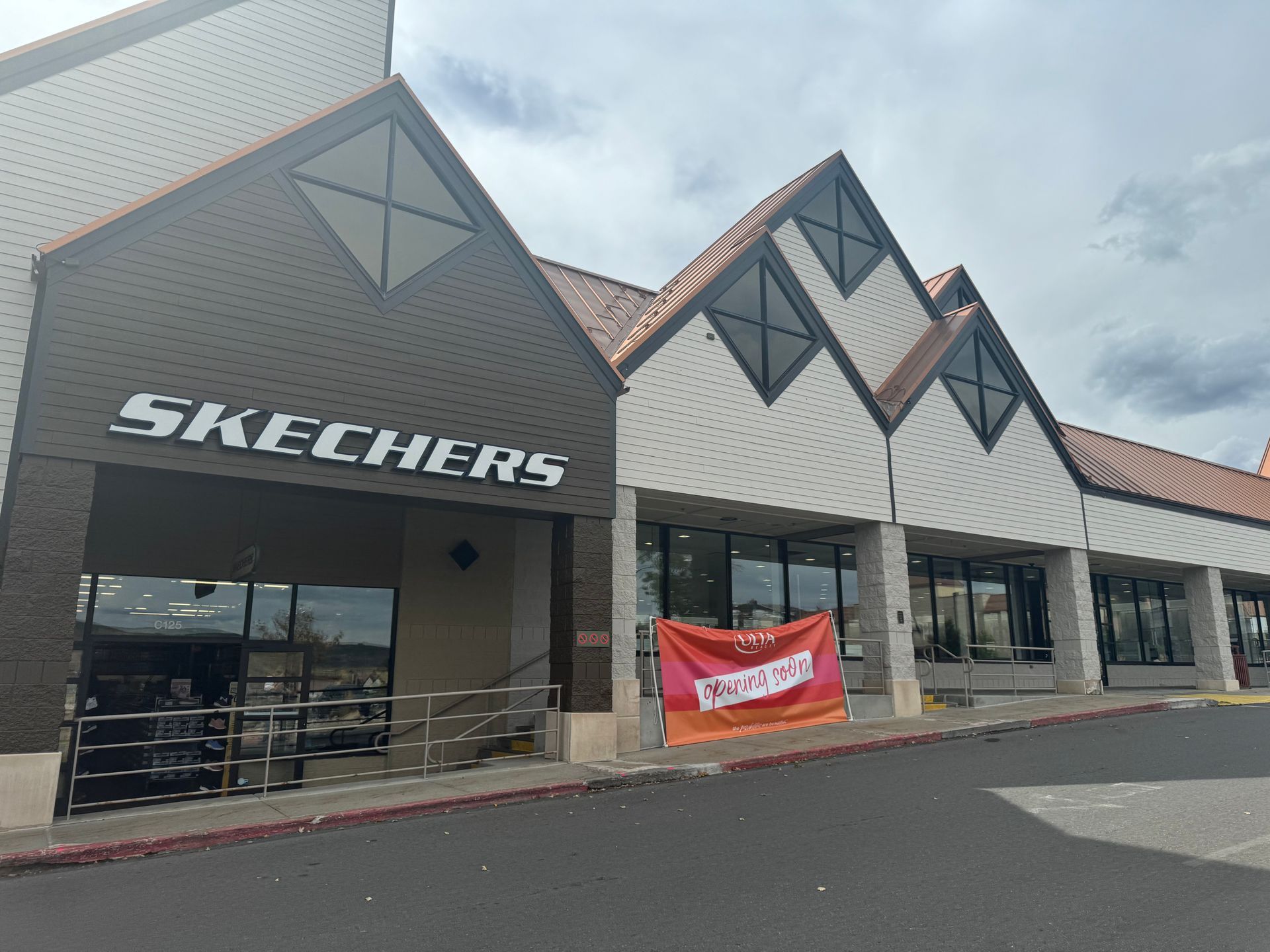 The front of a skechers store with a sign that says skechers on it.