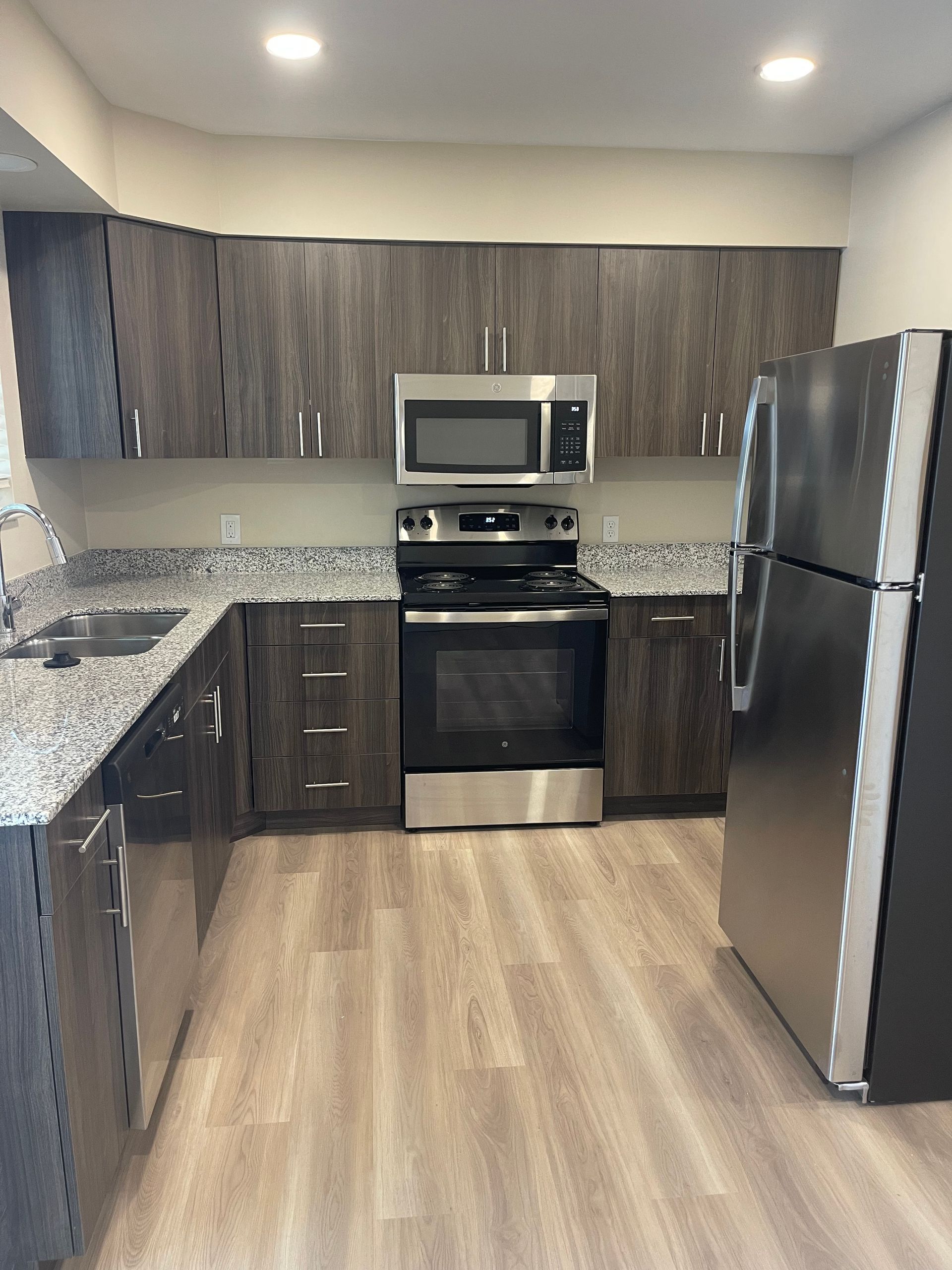 A kitchen with stainless steel appliances and granite counter tops.