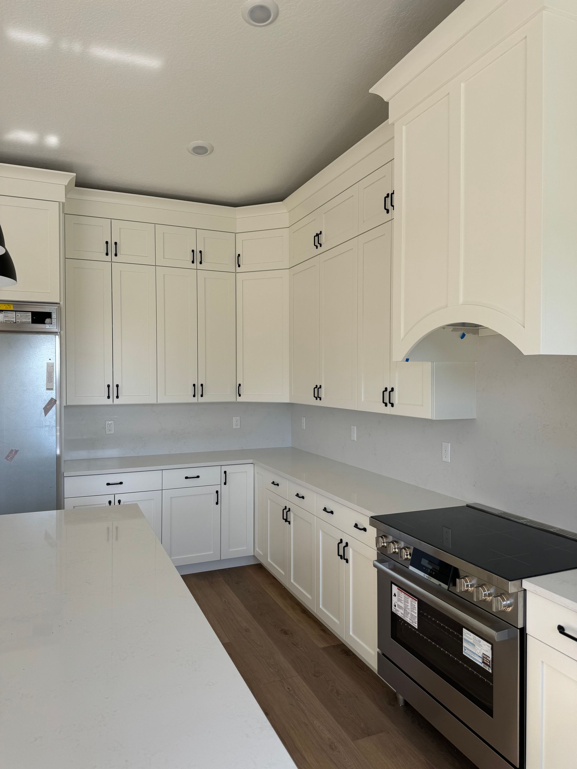 A kitchen with white cabinets and stainless steel appliances