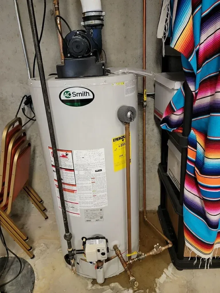 A.O. Smith water heater in a basement, with pipes and a vent.