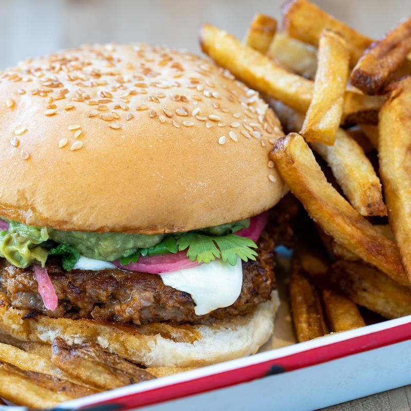 A hamburger and french fries in a tray on a table