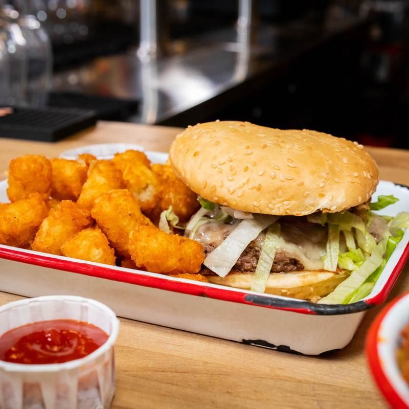 A hamburger and chicken nuggets are in a tray on a table.
