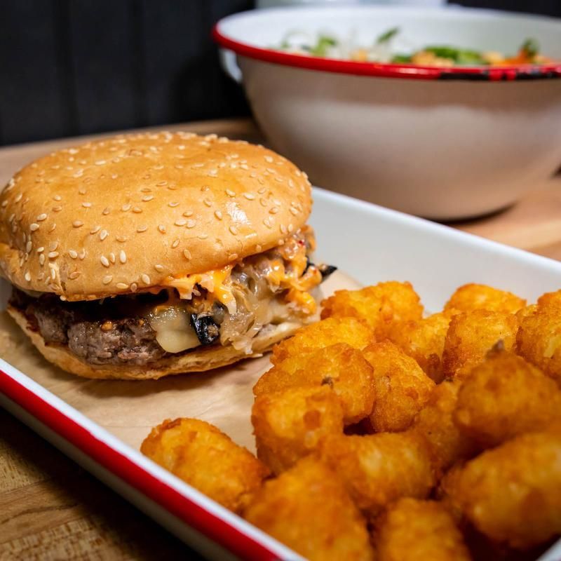 A plate of food with a hamburger and potatoes on it