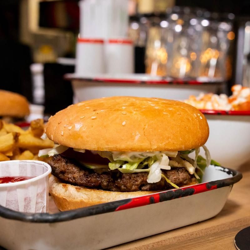 A hamburger and french fries in a tray on a table