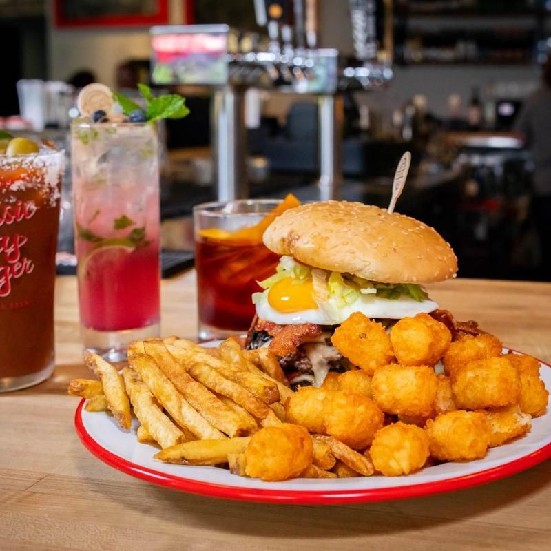 A plate of food with a hamburger and french fries on a table.