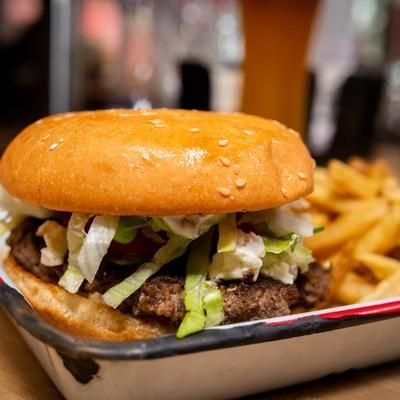 A hamburger and french fries in a tray on a table.