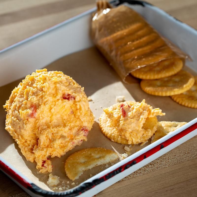 A tray filled with crackers and a ball of dip