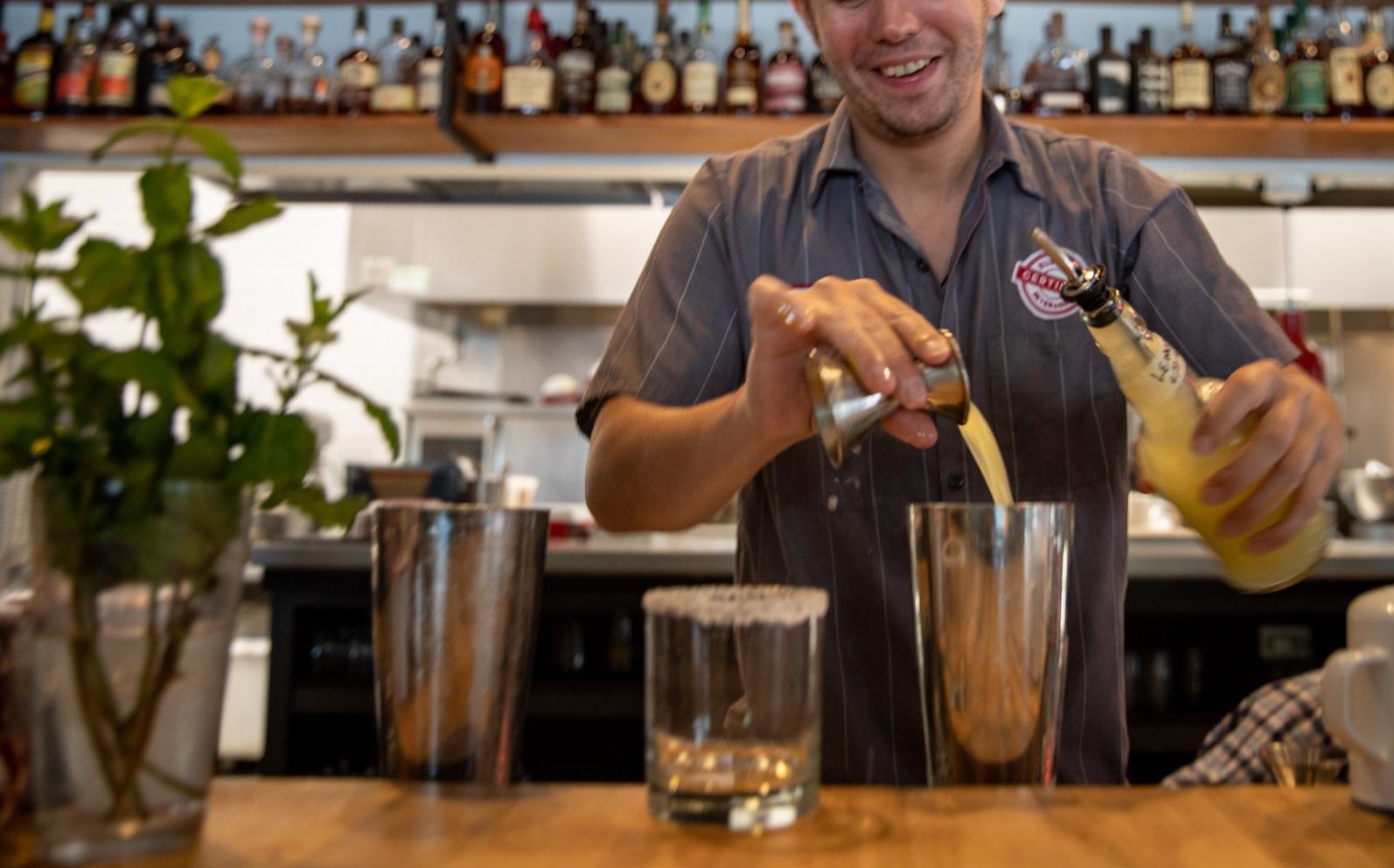 a bartender is pouring a drink into a glass