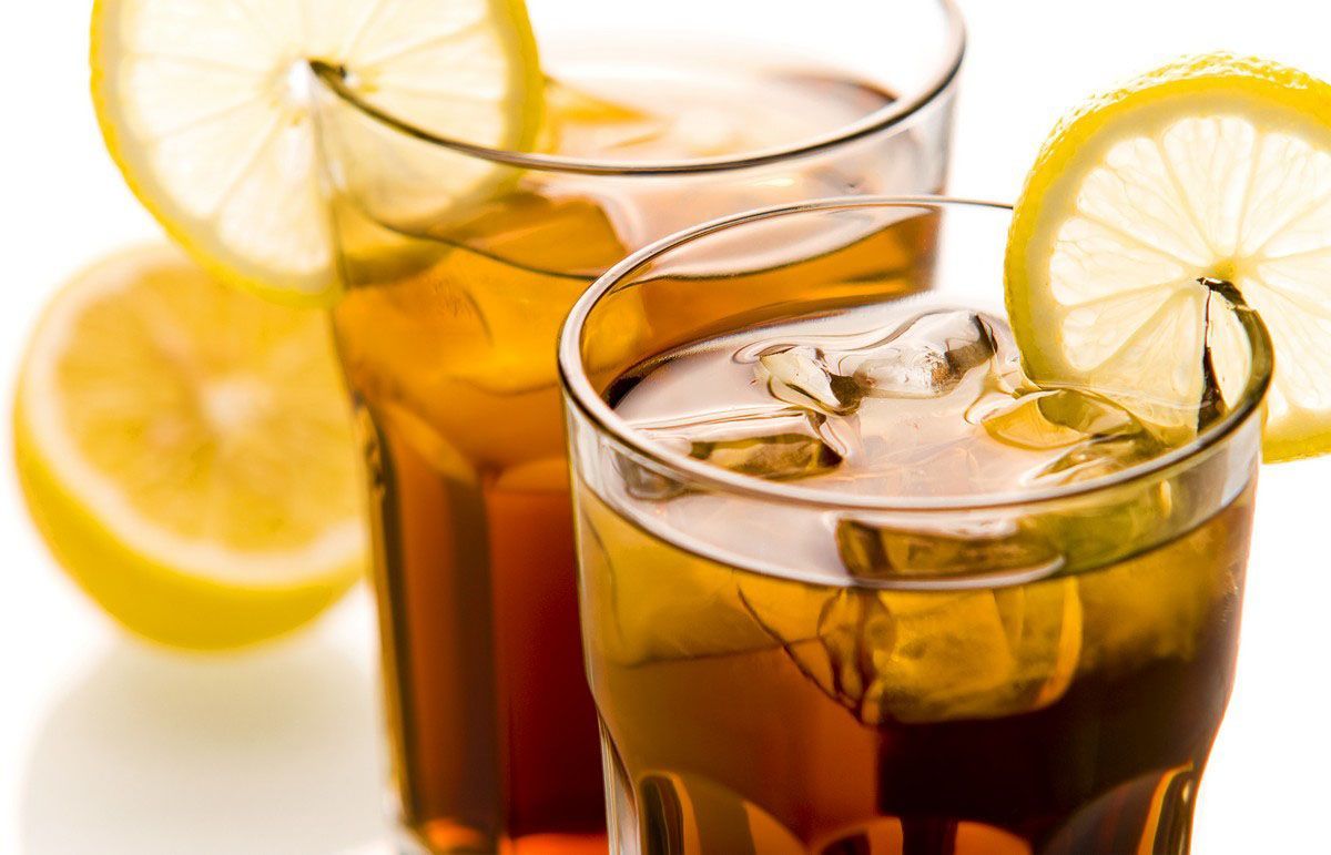 Two glasses of iced tea with lemon slices on a table.