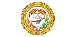 Seal of the North Carolina Department of Agriculture and Consumer Services featuring a plow and scales, founded 1877.