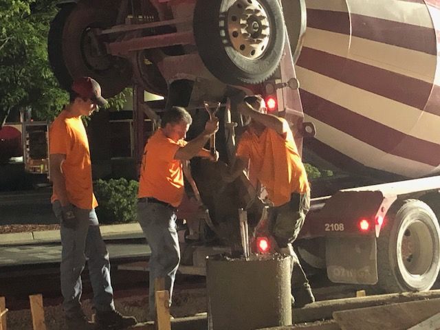 3 men operating the cement truck