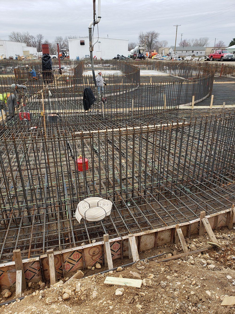 a construction site with a lot of steel bars and a crane in the background