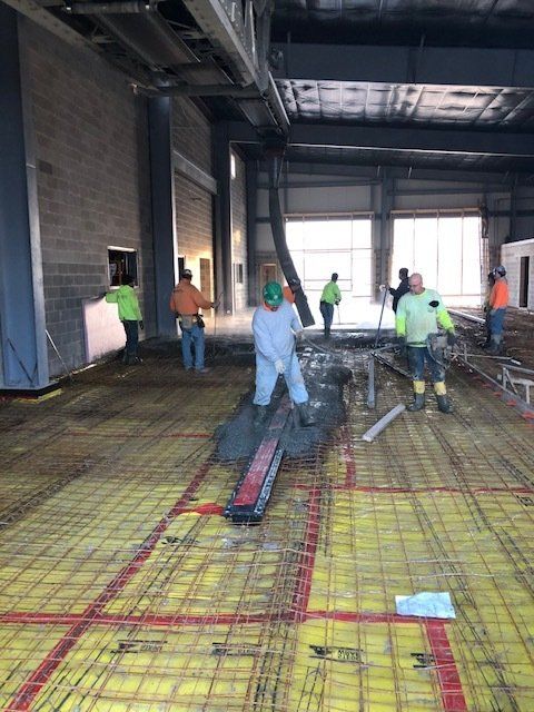 a group of construction workers are working on the floor of a building