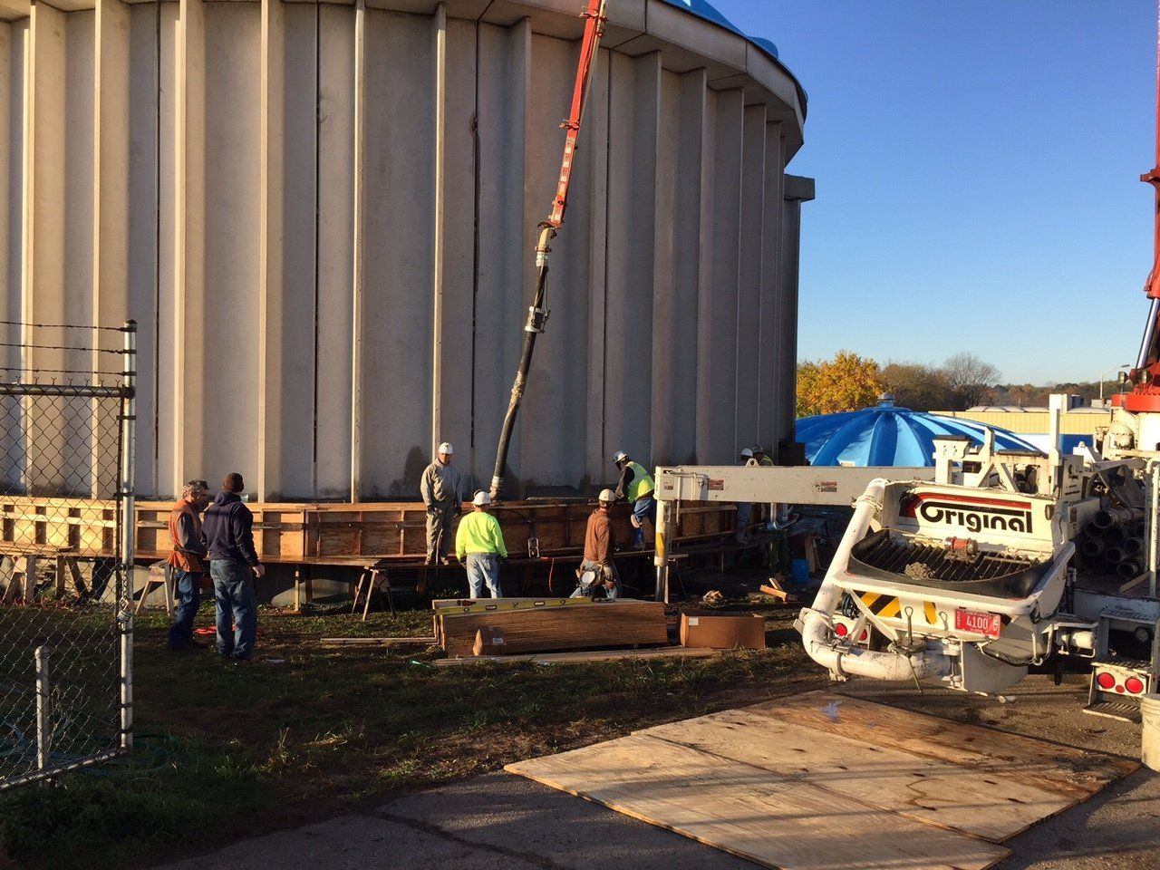 a group of construction workers are working on a large tank