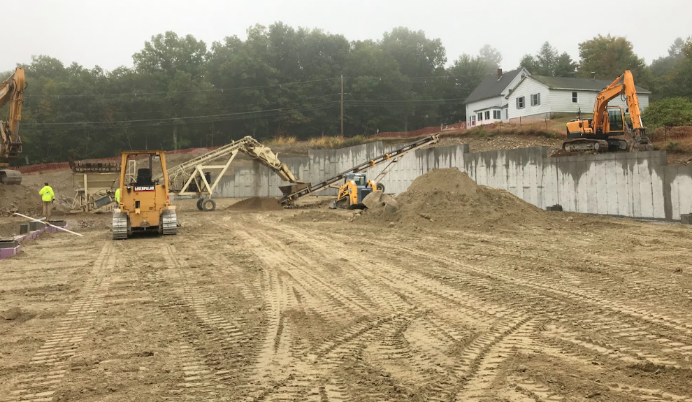 A house is being built in the middle of a dirt field.