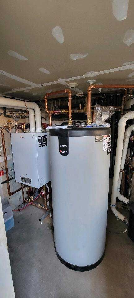 A water heater and heating system installed in a basement. Copper piping connects to the top of the water heater.