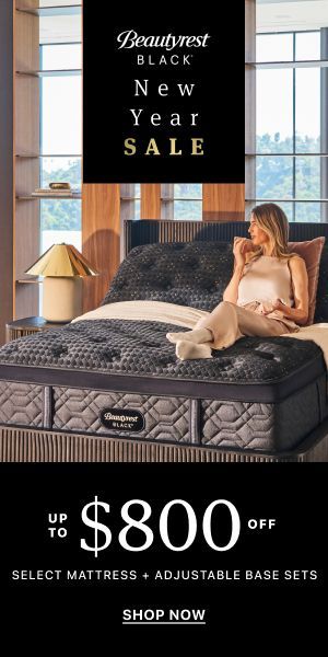 A woman is sitting on a bed with a mattress on it.