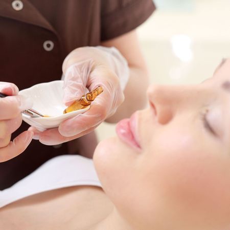 A woman is getting a facial treatment at a beauty salon.