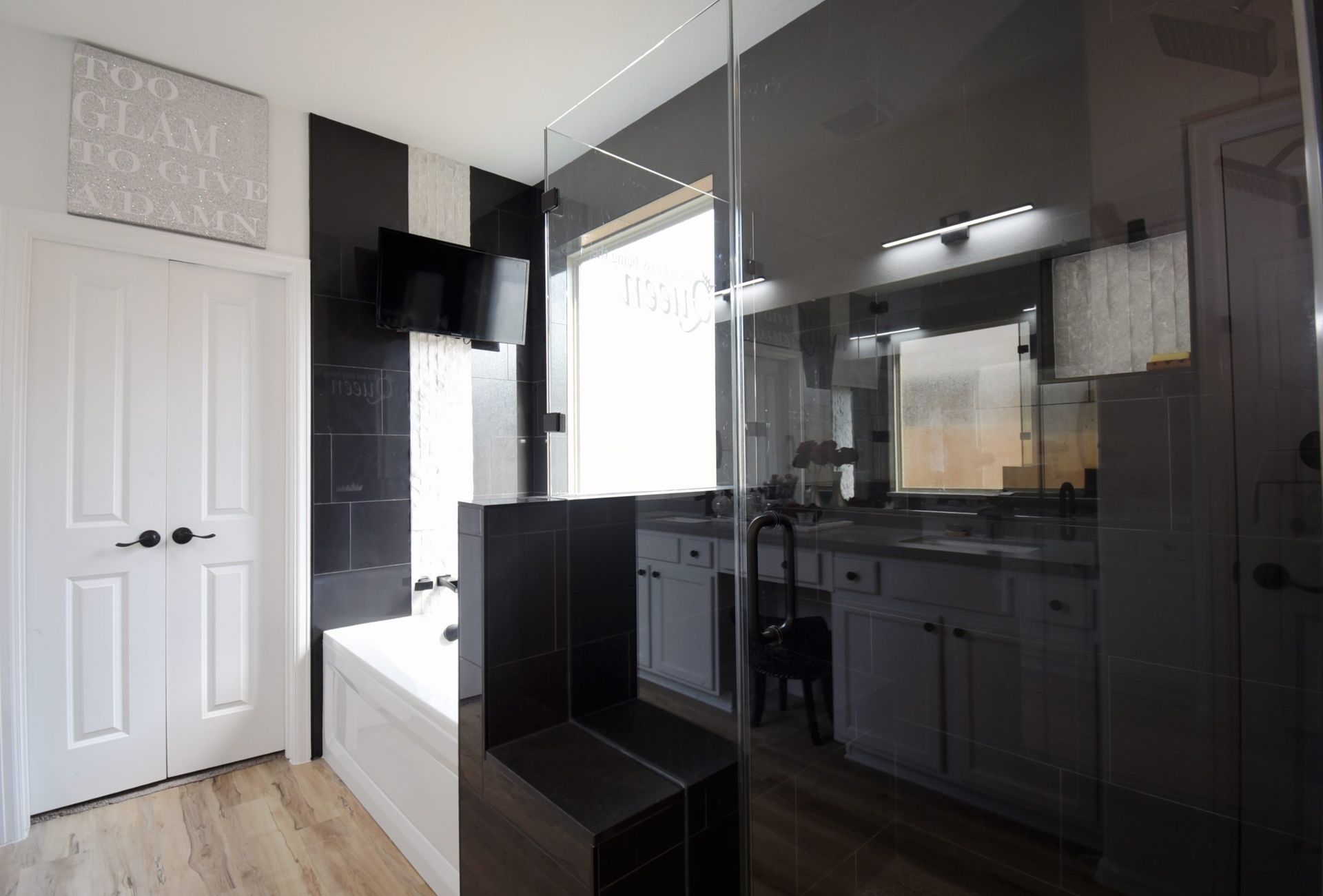 Modern bathroom with a black and white striped accent wall and a large mirror.