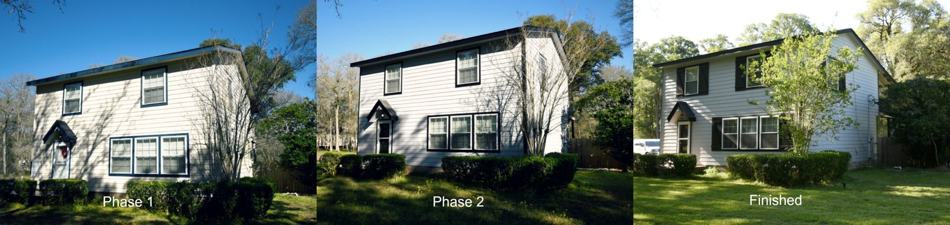 Three similar two-story white houses with dark trim and green shrubs under a blue sky.